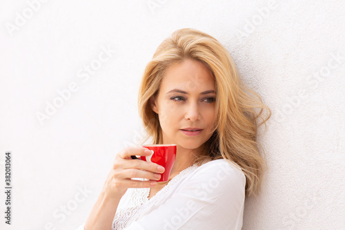 Close up of a beautiful blonde woman drinking coffee