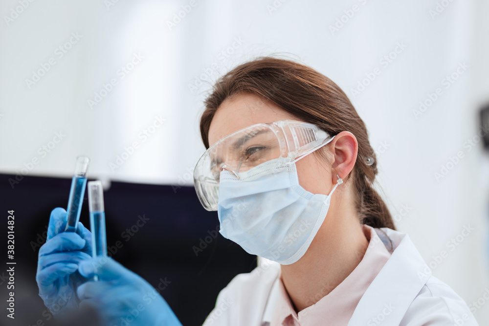 close up. female scientist looking at liquid in test tubes. close up. female scientist looking at liquid in test tubes.