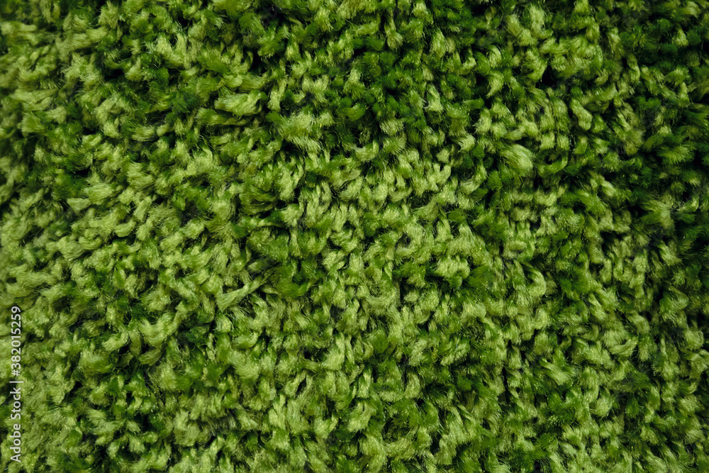 Green wool carpet close-up. Soft loop pile surface.