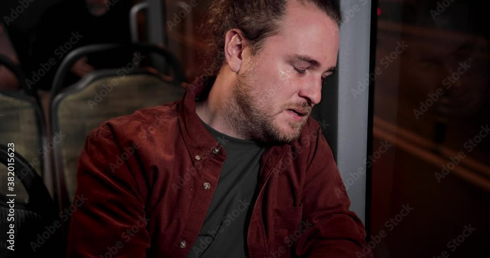 Sad caucasian man in tears sitting on public bus crying Sad caucasian man in tears sitting on public bus crying