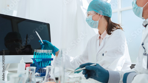 group of scientists looking at a computer screen in the laboratory.