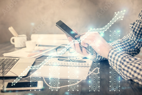 Double exposure of man's hands holding and using a digital device and forex graph drawing. Financial market concept.