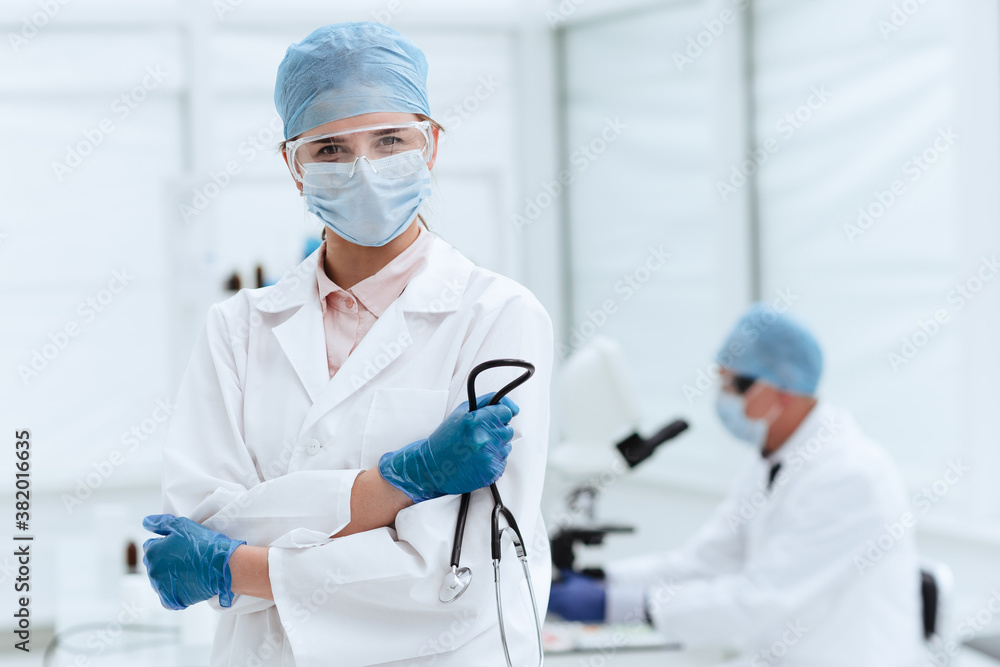 serious woman doctor with a stethoscope standing in a medical laboratory . serious woman doctor with a stethoscope standing in a medical laboratory .