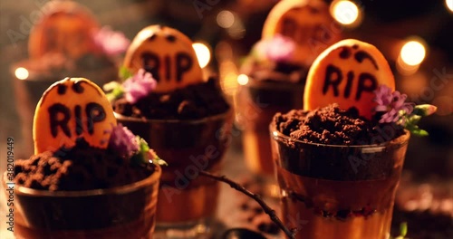 Graveyard chocolate mousse cups with tombstone cookies, halloween dessert photo