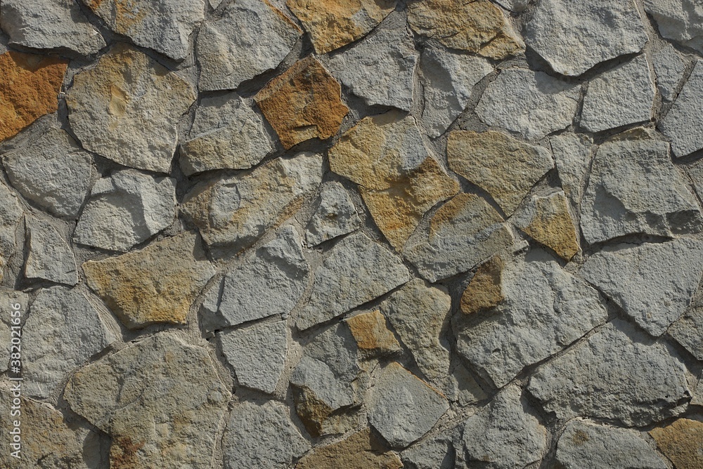 gray  brown stone texture of large cobblestones in the wall of the fence