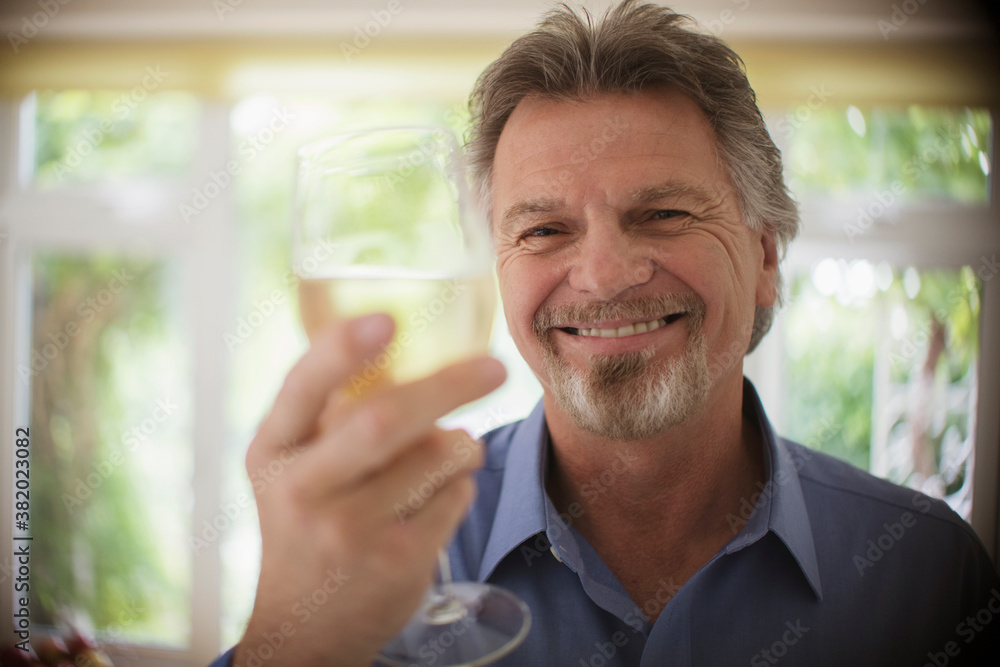Close up portrait happy carefree senior man drinking white wine Close up portrait happy carefree senior man drinking white wine