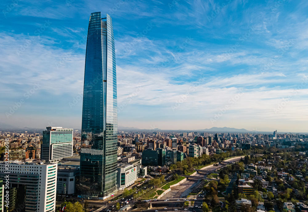 The tallest building in Chile at a sunny day with a park and a river by the side. The financial center of the city  - obrazy, fototapety, plakaty 