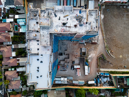 A building under construction with fifteen floors looked from above to the rooftop with a drone in the middle of an urban neighborhood  © Francesco