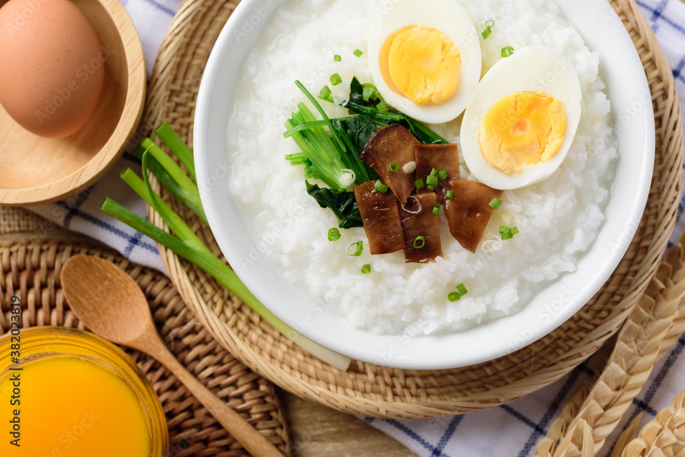 Asian breakfast food, Rice soup with boiled egg, grilled mushroom and spinach in bowl