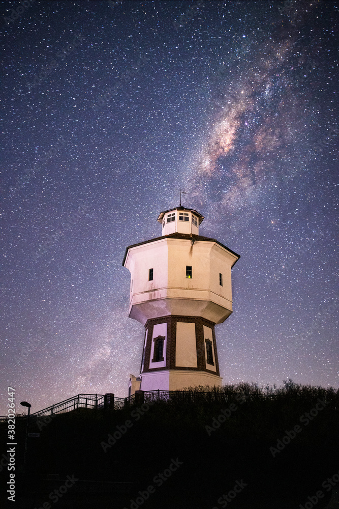 Langeoog Wasserturn - Watertower at night with the Milky way galaxy and a bright night sky in the background