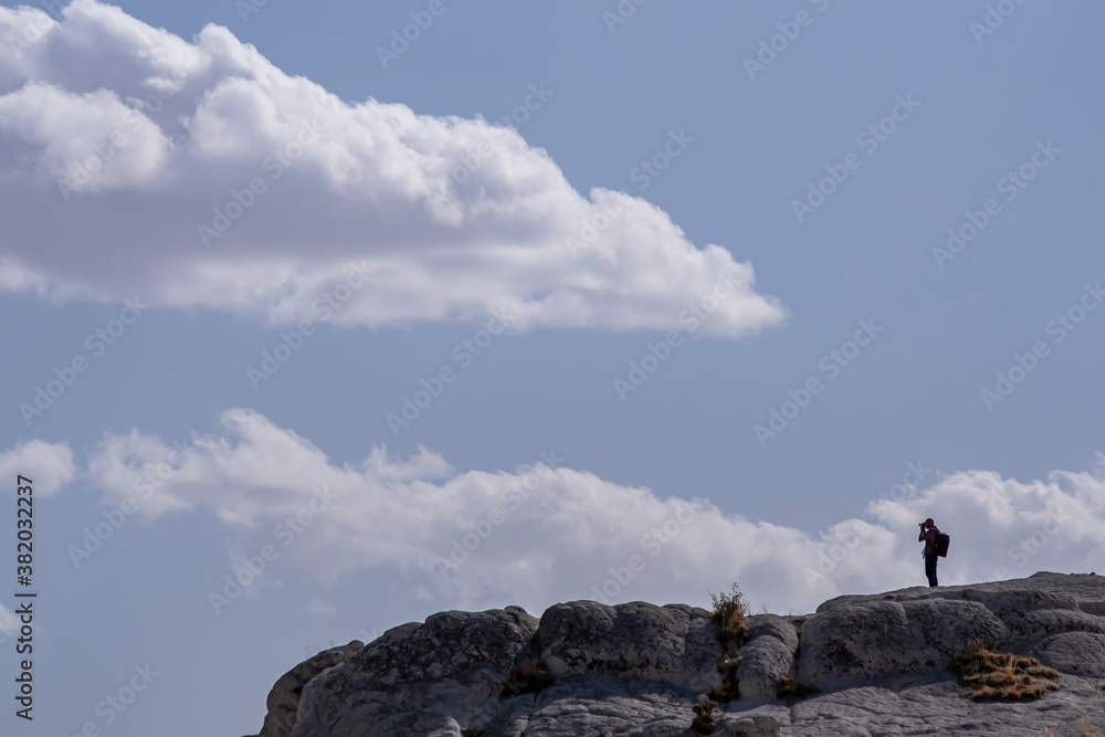 A photographer man standing on the top of the hill and taking shots in Cappadocia, Turkey.