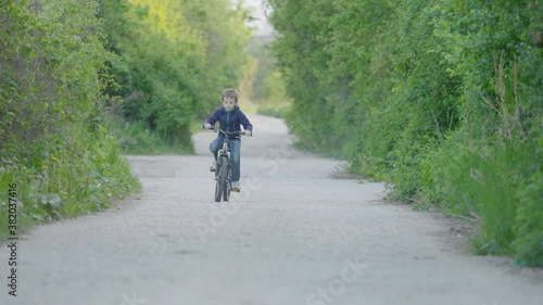 Wallpaper Mural Child riding a bicycle on forest path with green trees, free childhood Torontodigital.ca
