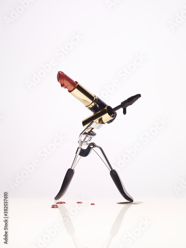 Image of eyelash curler, mascara and lipstick