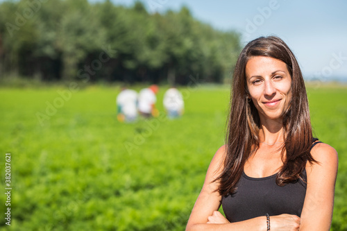 Fière entrepreneure devant un champ de carottes
