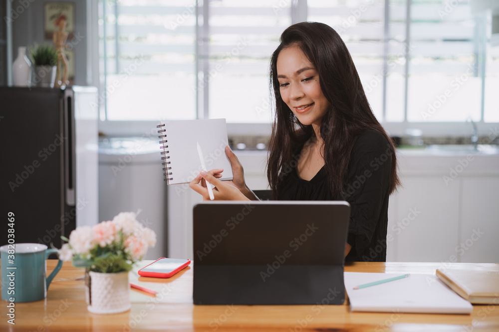 Happy young businesswoman working on a laptop computer in office at her home. Working at home concept Happy young businesswoman working on a laptop computer in office at her home. Working at home concept