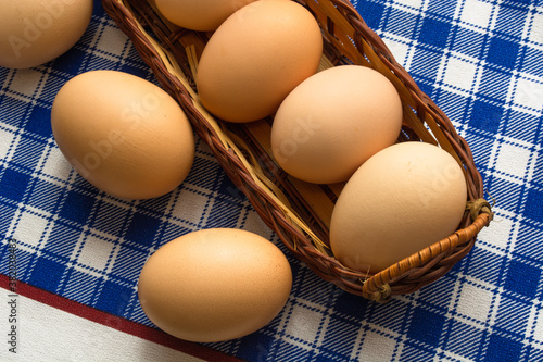 eggs in an oblong wicker basket on a bright checkered striped background