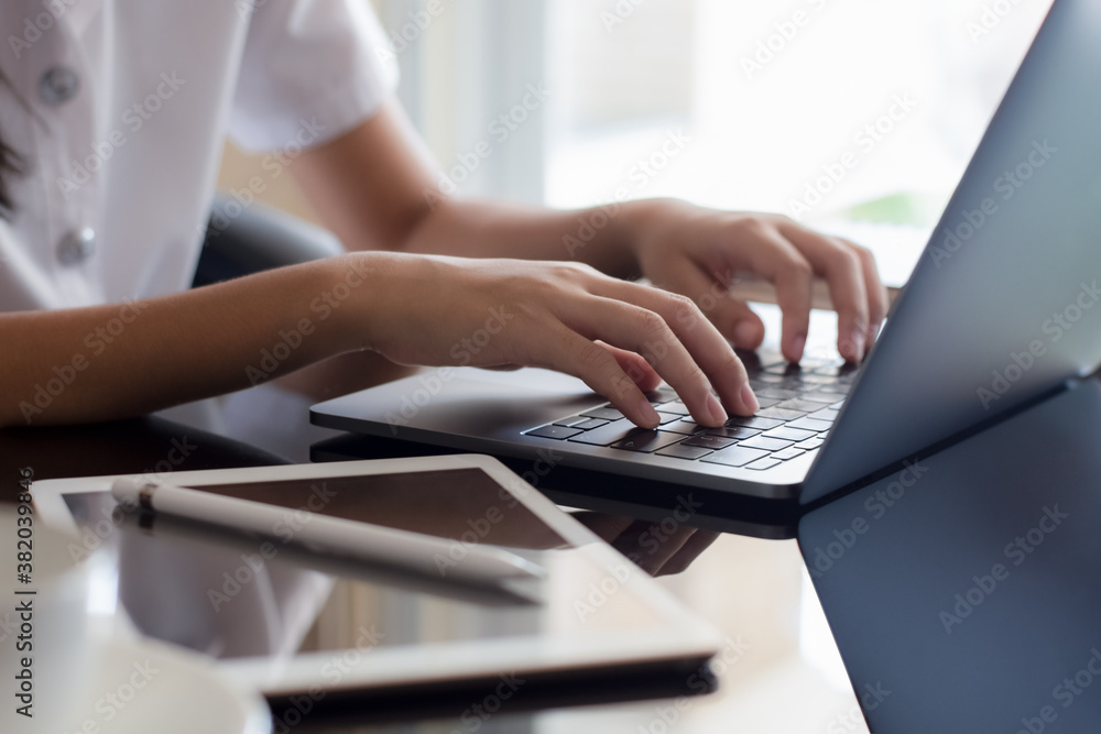 Woman's hands work and typing on laptop computer with digital tablet and stylus pen on the desk at workplace. Woman's hands work and typing on laptop computer with digital tablet and stylus pen on the desk at workplace.