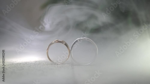 wedding rings on a floor with smoke