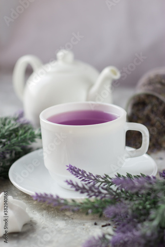 Wallpaper Mural lavender tea in a white mug. Purple tea in a mug on a light background stands on the table next to lavender flowers. Dried lavender flowers are brewed in a Cup. Torontodigital.ca