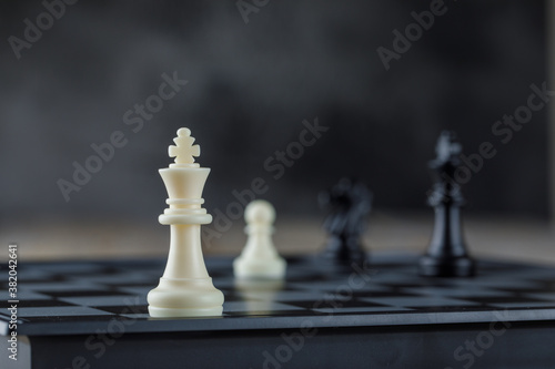 Business strategy concept with chessboard with figures on blurred background side view.