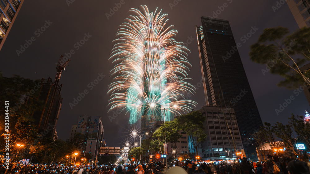 Obraz premium Taipei City Night landscape and Taipei 101 skyscraper is lit up by fireworks. People watching and taking photos and videos around buildings to celebrate the new year event.