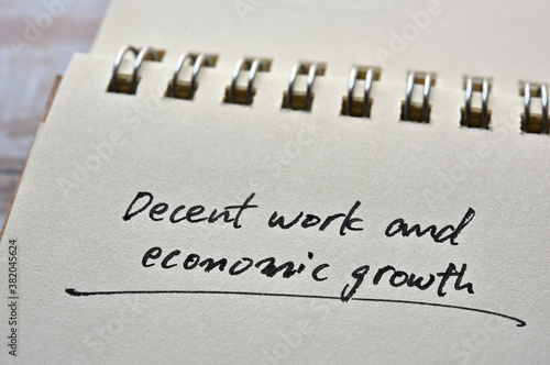 At the edge of the notebook, "Decent work and economic growth" is written. Close-up.