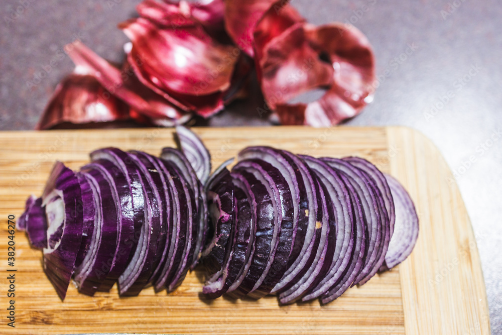simple food ingredients, red spanish onion chopped into half moons on cutting board simple food ingredients, red spanish onion chopped into half moons on cutting board
