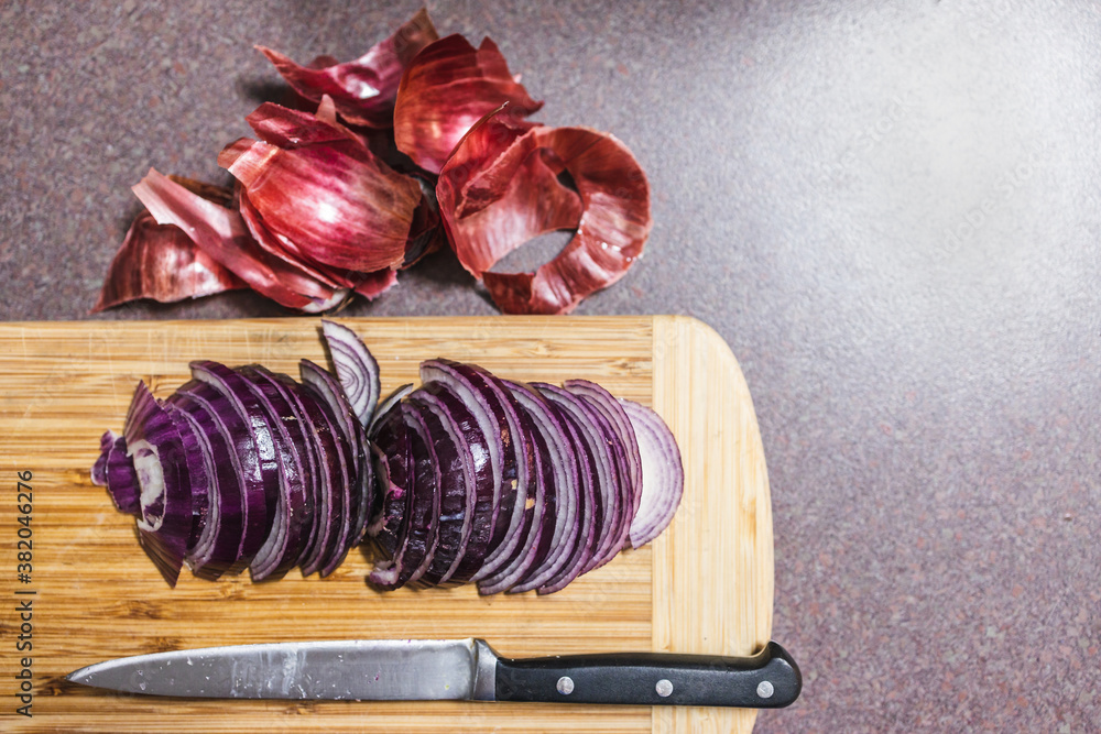 simple food ingredients, red spanish onion chopped into half moons on cutting board simple food ingredients, red spanish onion chopped into half moons on cutting board