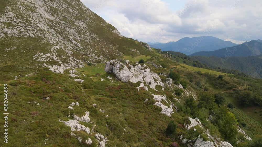 Rocky outcrop on colorful mountain side, Redes Natural Park, drone orbit shot Rocky outcrop on colorful mountain side, Redes Natural Park, drone orbit shot