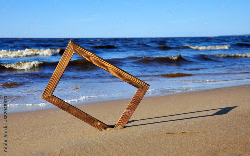 Photo frame on the sand by the sea. Background Photo frame on the sand by the sea. Background