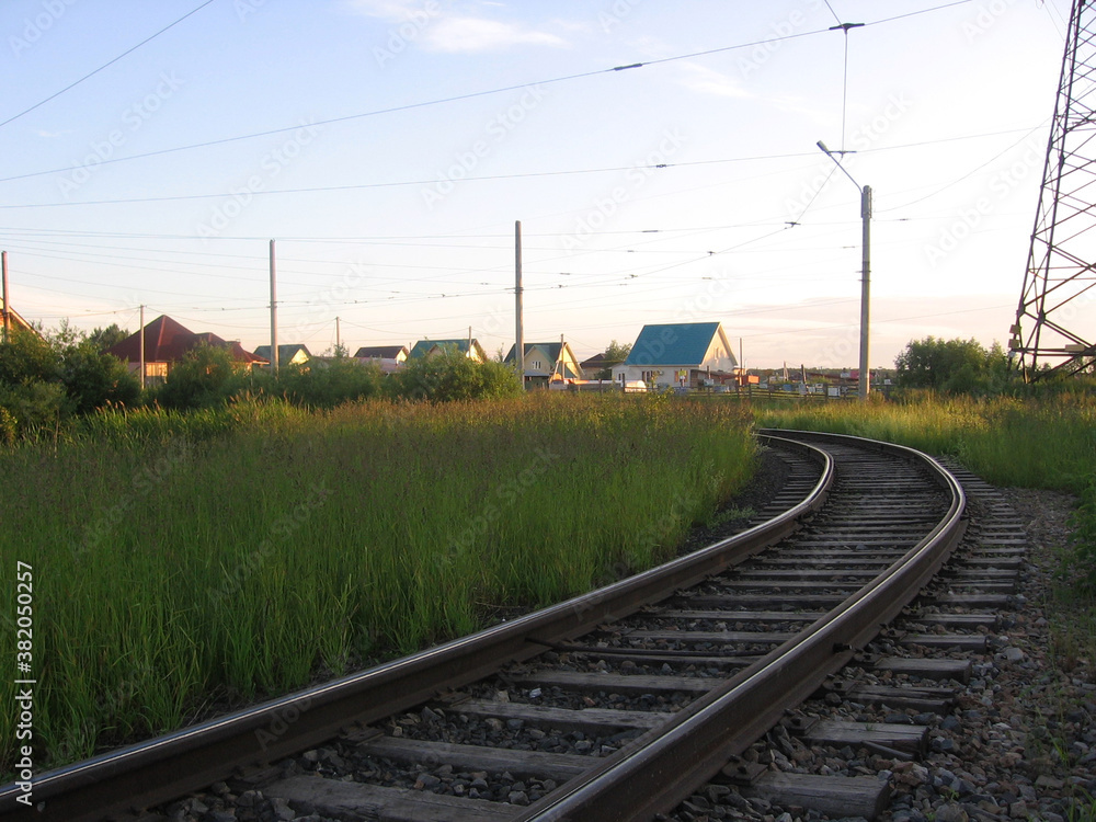 Fototapeta premium tram rails laid lead to houses in a residential area