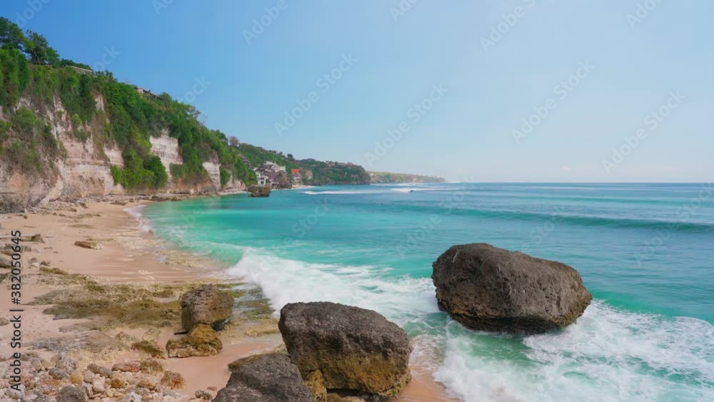 Azure beach with rocky mountains and clear water of Indian ocean at sunny day. Hidden beach in Bali, Indonesia Azure beach with rocky mountains and clear water of Indian ocean at sunny day. Hidden beach in Bali, Indonesia