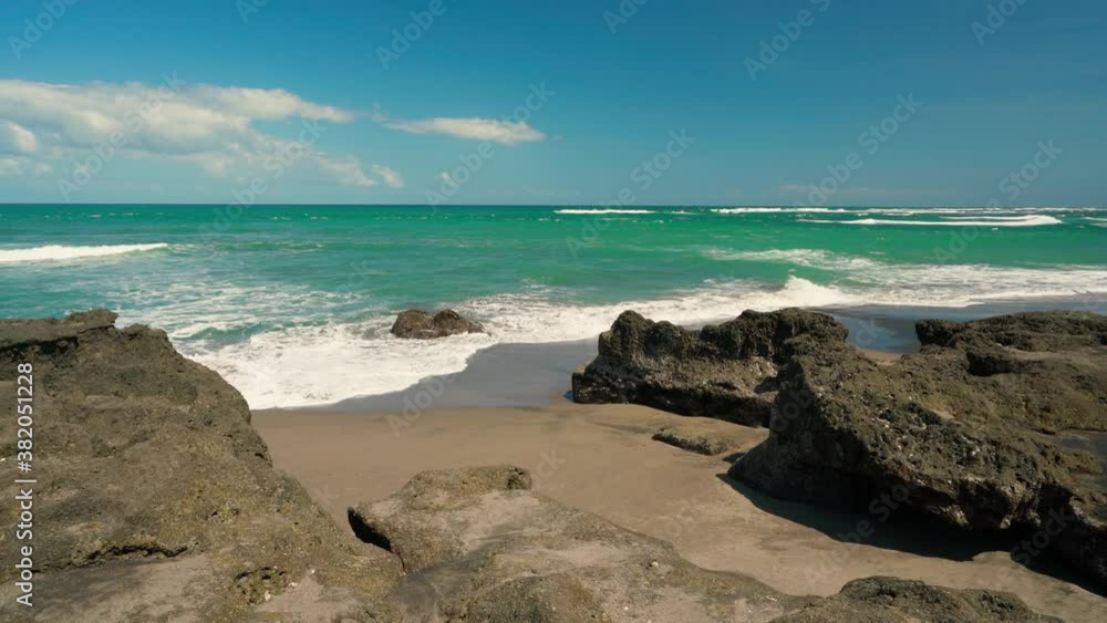 Canggu Beach with black sand beach and beautiful ocean on background blue sky. Canggu, Bali, Indonesia. 4K Canggu Beach with black sand beach and beautiful ocean on background blue sky. Canggu, Bali, Indonesia. 4K