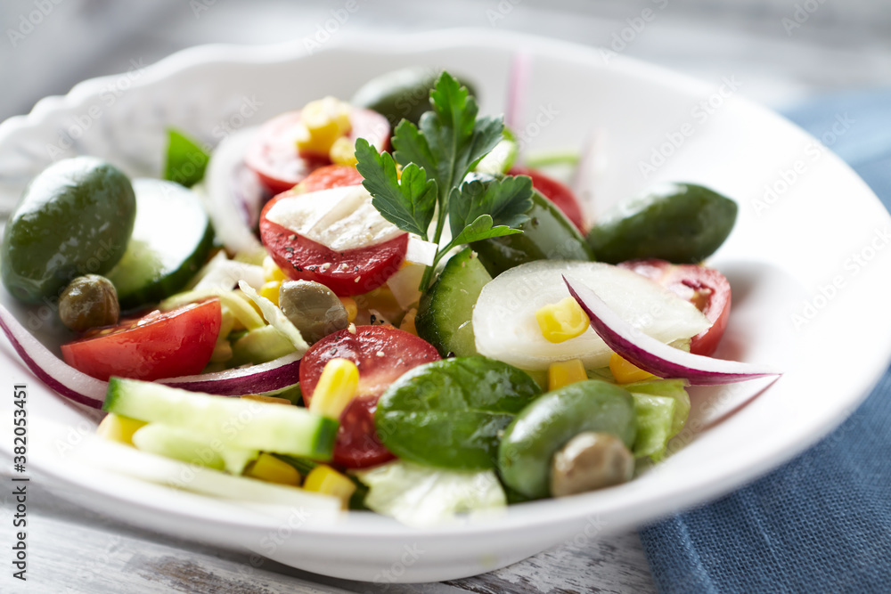 Healthy Salad with Green Olives, Baby Spinach, Cucumber, Cherry Tomatoes and Capers. Bright wooden background. Close up. Healthy Salad with Green Olives, Baby Spinach, Cucumber, Cherry Tomatoes and Capers. Bright wooden background. Close up.