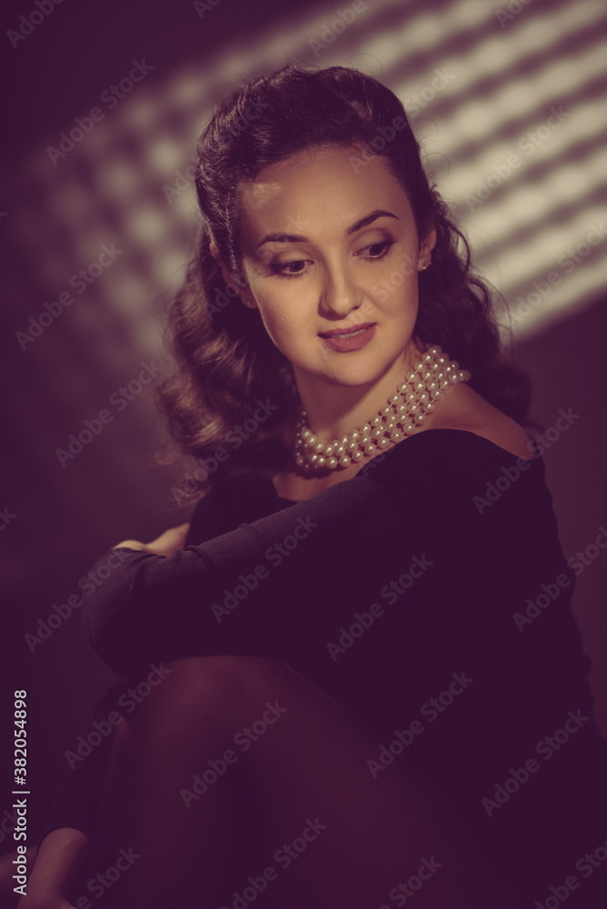 Glamorous brunette woman posing with jewelry pearl necklace. image toned in warm colors in retro style Glamorous brunette woman posing with jewelry pearl necklace. image toned in warm colors in retro style