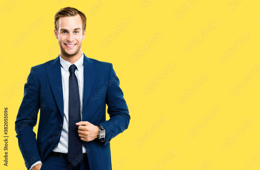 Portrait image of happy confident businessman in blue suit and tie, isolated over yellow background. Business success concept. Smiling man at studio picture. Copyspace for some text. Portrait image of happy confident businessman in blue suit and tie, isolated over yellow background. Business success concept. Smiling man at studio picture. Copyspace for some text.