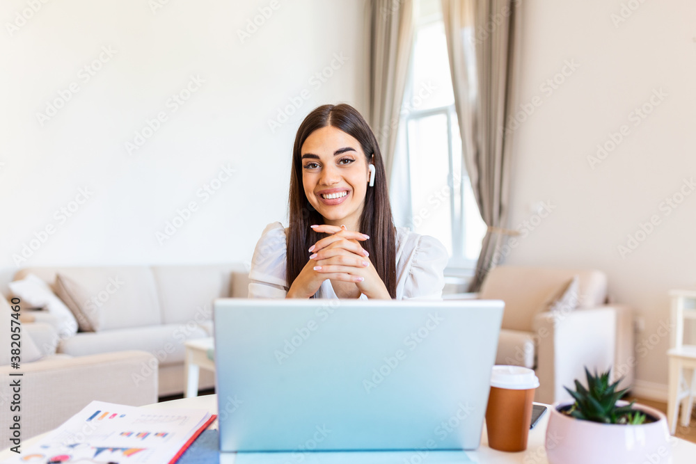 Happy young woman in headphones speaking looking at laptop making notes, girl student talking by video conference call, female teacher trainer tutoring by webcam, online training, e-coaching concept Happy young woman in headphones speaking looking at laptop making notes, girl student talking by video conference call, female teacher trainer tutoring by webcam, online training, e-coaching concept