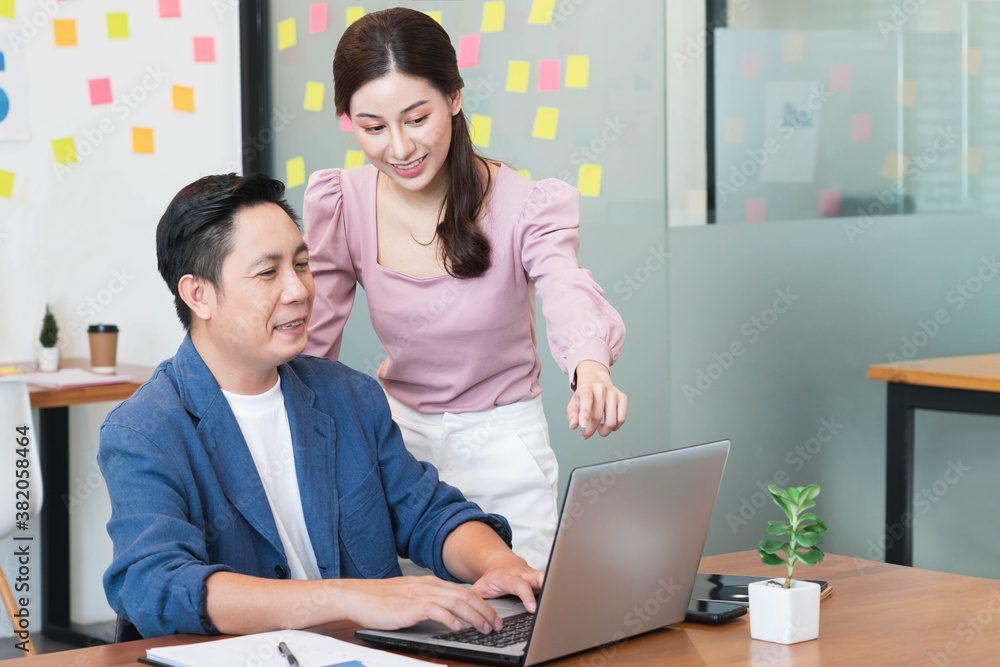 Young beautiful business woman Talking to her male Manager While pointing at his Computer on Table at workplace Young beautiful business woman Talking to her male Manager While pointing at his Computer on Table at workplace