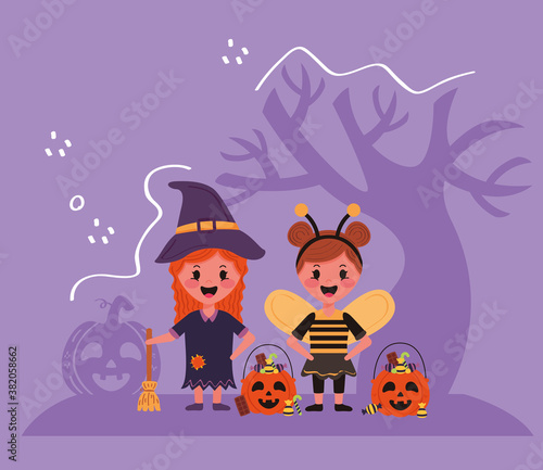 little kids with halloween costumes characters and tree
