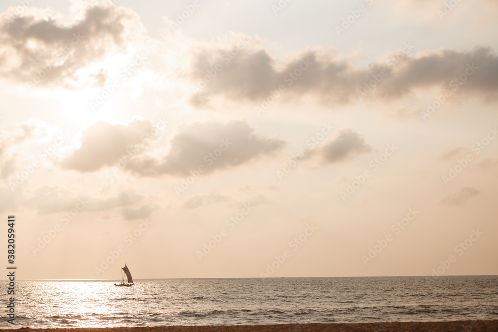 Small ship sailing at colorful sunset in Sri Lanka
