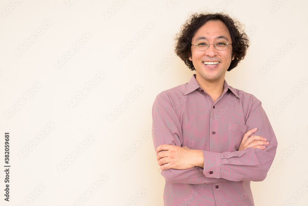 Portrait of happy Japanese businessman smiling with arms crossed - obrazy, fototapety, plakaty 
