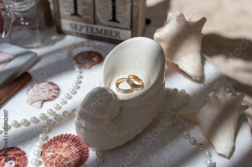 Fotografie Close up view of wedding rings in the white ceramic shell on the table with wedd