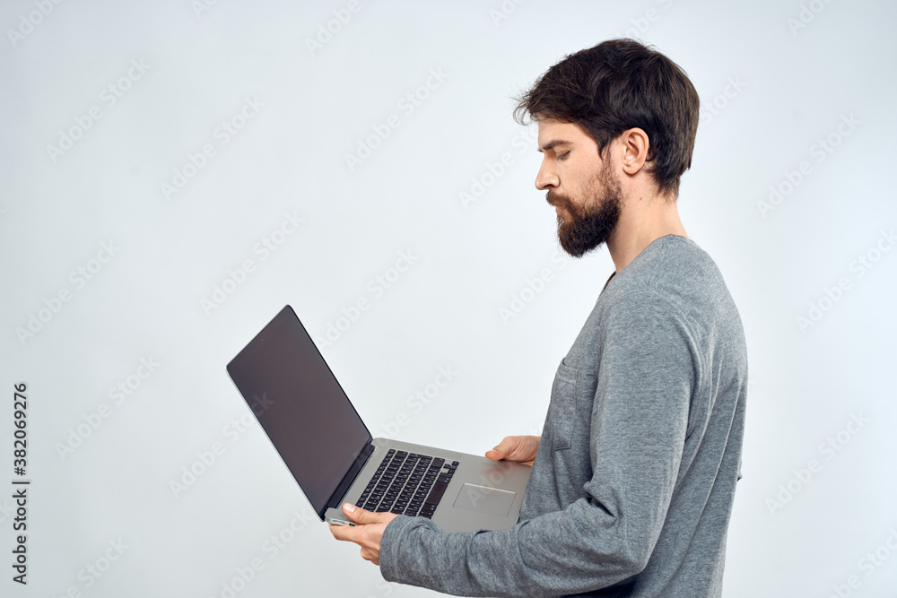 A man in a gray sweater with a laptop hands lifestyle technology communication internet work A man in a gray sweater with a laptop hands lifestyle technology communication internet work