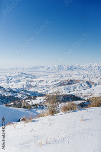 Picturesque Tien Shan mountains in Uzbekistan, covered with snow, winter clear Sunny day in the mountains. Amazing panorama in Beldersay