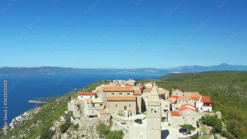 Aerial view of small historical town of Lubenice on the high cliff, Cres island in Croatia, Adriatic sea in background, drone reveal footage Aerial view of small historical town of Lubenice on the high cliff, Cres island in Croatia, Adriatic sea in background, drone reveal footage