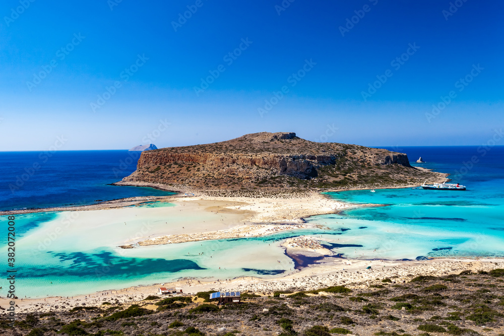 Balos lagoon on Crete island, Greece. Tourists relax and bath in crystal clear water of Balos beach. The most unique natural attraction in Crete.