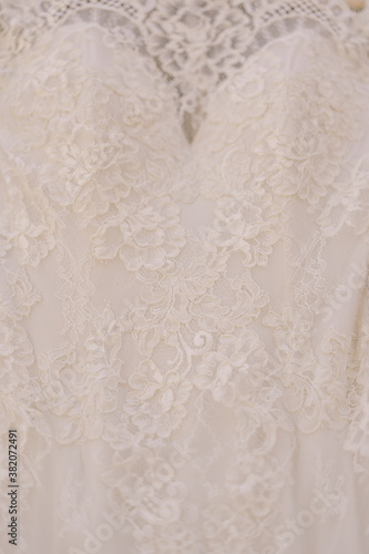 Close-up of the texture of the pattern of the bride's dress at the bust of the attire.
