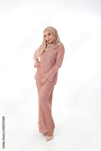 South east Asian Malay race ethnic origin woman wearing dress costume baju kurung tuding headscarf on white background photo