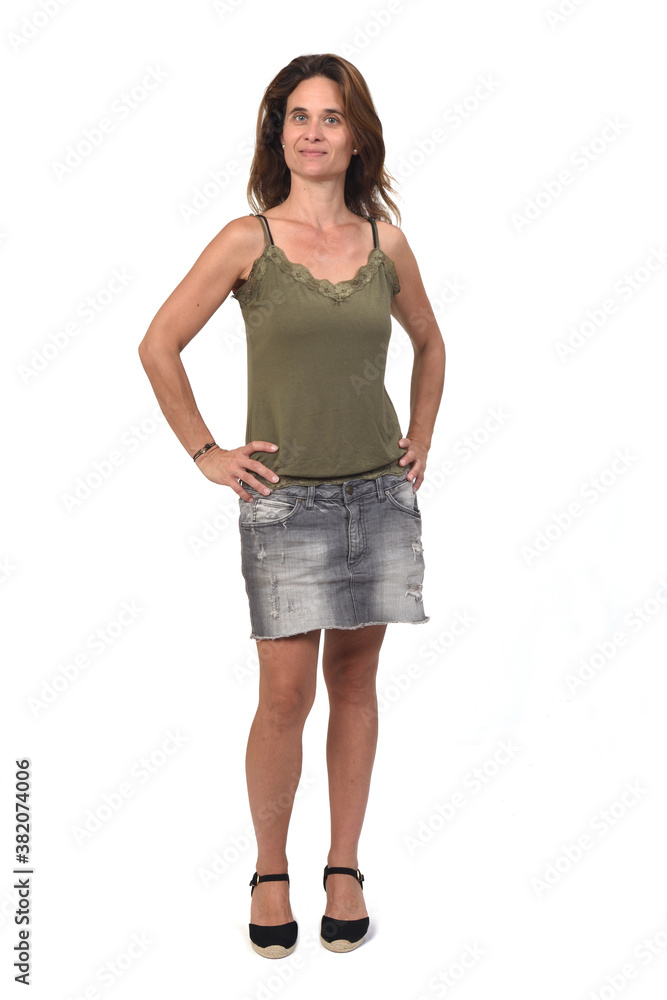 front view of the full portrait of a woman in a denim skirt on white background, hands on hip front view of the full portrait of a woman in a denim skirt on white background, hands on hip