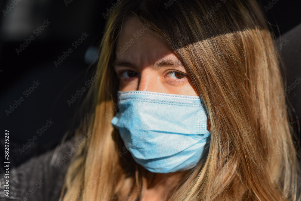 woman wears a medical mask because air pollution or virus is an epidemic in the city. Breathing protection concept. Woman in medical mask looking at the camera woman wears a medical mask because air pollution or virus is an epidemic in the city. Breathing protection concept. Woman in medical mask looking at the camera